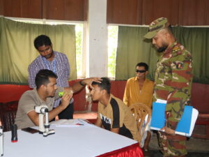 জার্নাল প্রতিবেদক পার্বত্য চট্টগ্রামের দুর্গম এলাকার মানুষের জন্য চিকিৎসাসেবা আরও সহজলভ্য করতে বাংলাদেশ সেনাবাহিনীর দীঘিনালা জোনের উদ্যোগে চক্ষু অপারেশন-পরবর্তী রোগীদের নিয়ে ফলো-আপ মেডিকেল ক্যাম্প অনুষ্ঠিত হয়েছে। অপারেশনের পর রোগীদের শারীরিক অবস্থা পর্যবেক্ষণ, প্রয়োজনীয় চিকিৎসা পরামর্শ এবং ওষুধ সরবরাহের মাধ্যমে এই কার্যক্রম পরিচালনা করা হয়। শুক্রবার (৭ আগস্ট) দীঘিনালা জোন সদর দপ্তরে দিনব্যাপী এ ফলো-আপ চিকিৎসা কার্যক্রম অনুষ্ঠিত হয়। এতে চট্টগ্রামের লায়ন্স চ্যারিটেবল আই হাসপাতালের দুইজন বিশেষজ্ঞ চিকিৎসক ও একজন প্যারামেডিক অংশ নেন। ক্যাম্পে গত ২৫ জুলাই লায়ন্স চ্যারিটেবল আই হাসপাতালে চক্ষু অপারেশন সম্পন্ন করা ২৮ জন রোগীর স্বাস্থ্য পরীক্ষা করা হয়। তাঁদের মধ্যে ১৩ জন পাহাড়ি এবং ১৫ জন বাঙালি রোগী ছিলেন। অপারেশনের পর প্রত্যন্ত এলাকায় বসবাসকারী এসব রোগীর নিয়মিত চিকিৎসা তদারকি নিশ্চিত করতেই এই ফলো-আপ কার্যক্রমের আয়োজন করা হয়। চিকিৎসকরা রোগীদের চোখের অপারেশন-পরবর্তী অবস্থা পরীক্ষা করে প্রয়োজনীয় চিকিৎসা পরামর্শ দেন। একই সঙ্গে চোখের পরিচর্যা, নিয়মিত ওষুধ ব্যবহার, দৈনন্দিন চলাফেরায় সতর্কতা এবং পরবর্তী সময়ে কী কী বিষয় মেনে চলতে হবে সে বিষয়ে রোগী ও তাঁদের স্বজনদের বিস্তারিত দিকনির্দেশনা দেওয়া হয়। প্রয়োজন অনুযায়ী রোগীদের বিনামূল্যে প্রয়োজনীয় ওষুধও সরবরাহ করা হয়। দীঘিনালা জোনের রেজিমেন্টাল মেডিকেল অফিসারের (আরএমও) তত্ত্বাবধানে পরিচালিত এ কার্যক্রমে চিকিৎসাসেবার পাশাপাশি রোগীদের অপারেশন-পরবর্তী স্বাস্থ্যগত অগ্রগতিও পর্যবেক্ষণ করা হয়। এতে চক্ষু অস্ত্রোপচারের পর কোনো রোগী যেন চিকিৎসা তদারকি থেকে বাদ না পড়েন, সে বিষয়টিকে গুরুত্ব দেওয়া হয়। পার্বত্য চট্টগ্রামের প্রত্যন্ত ও দুর্গম অঞ্চলে বসবাসকারী মানুষের জন্য নিয়মিত বিশেষায়িত চিকিৎসাসেবা পাওয়া অনেক সময় কঠিন হয়ে পড়ে। বিশেষ করে অস্ত্রোপচারের পর নিয়মিত ফলো-আপের প্রয়োজন হলেও দূরত্ব, যাতায়াত ব্যয় ও আর্থিক সীমাবদ্ধতার কারণে অনেক রোগী কাঙ্ক্ষিত চিকিৎসা নিতে পারেন না। এমন বাস্তবতায় দীঘিনালা জোনের উদ্যোগে স্থানীয় পর্যায়ে ফলো-আপ চিকিৎসা পাওয়ার সুযোগ তৈরি হওয়ায় রোগী ও স্বজনদের মধ্যে স্বস্তি দেখা যায়। চিকিৎসা নিতে আসা রোগী ও তাঁদের স্বজনরা জানান, চক্ষু অপারেশনের পর আবার দূরের হাসপাতালে গিয়ে চিকিৎসা নেওয়া অনেকের জন্য কষ্টসাধ্য। দীঘিনালা জোন সদর দপ্তরে ফলো-আপের ব্যবস্থা করায় তাঁদের সময়, যাতায়াতের কষ্ট ও অতিরিক্ত ব্যয় অনেকটাই কমেছে। একই সঙ্গে বিশেষজ্ঞ চিকিৎসকদের কাছ থেকে সরাসরি পরামর্শ ও প্রয়োজনীয় ওষুধ পাওয়ায় তাঁরা উপকৃত হয়েছেন। রোগী ও তাঁদের স্বজনরা এ উদ্যোগের জন্য বাংলাদেশ সেনাবাহিনী এবং লায়ন্স চ্যারিটেবল আই হাসপাতাল, চট্টগ্রামের প্রতি আন্তরিক কৃতজ্ঞতা প্রকাশ করেন। তাঁদের মতে, শুধু অস্ত্রোপচার করানো নয়, অপারেশনের পর রোগীদের নিয়মিত খোঁজ নেওয়া ও চিকিৎসা তদারকির ব্যবস্থা করা অত্যন্ত গুরুত্বপূর্ণ। এ ধরনের উদ্যোগ দুর্গম এলাকার মানুষের চিকিৎসাসেবার প্রতি আস্থা আরও বাড়াতে সহায়ক হবে। সংশ্লিষ্টরা জানান, দুর্গম পার্বত্য এলাকায় বসবাসকারী সাধারণ মানুষের কাছে স্বাস্থ্যসেবা পৌঁছে দিতে বাংলাদেশ সেনাবাহিনী বিভিন্ন সময়ে চিকিৎসা ক্যাম্প, বিশেষজ্ঞ চিকিৎসাসেবা এবং মানবিক সহায়তা কার্যক্রম পরিচালনা করে আসছে। এরই ধারাবাহিকতায় চক্ষু অপারেশন-পরবর্তী রোগীদের জন্য এই ফলো-আপ মেডিকেল ক্যাম্পের আয়োজন করা হয়েছে। বাংলাদেশ সেনাবাহিনীর দীঘিনালা জোনের পক্ষ থেকে জানানো হয়েছে, পার্বত্য চট্টগ্রামের দুর্গম এলাকায় বসবাসরত জনগণের মানসম্মত স্বাস্থ্যসেবা নিশ্চিত করা এবং প্রয়োজনের সময় তাঁদের পাশে দাঁড়ানোর লক্ষ্যে এ ধরনের জনকল্যাণমূলক কার্যক্রম ভবিষ্যতেও অব্যাহত থাকবে। চক্ষু চিকিৎসার মতো গুরুত্বপূর্ণ ও বিশেষায়িত সেবা প্রত্যন্ত মানুষের দোরগোড়ায় পৌঁছে দেওয়ার পাশাপাশি অপারেশন-পরবর্তী চিকিৎসা নিশ্চিত করার এই উদ্যোগকে স্থানীয়রা মানবিক ও সময়োপযোগী পদক্ষেপ হিসেবে দেখছেন। তাঁদের প্রত্যাশা, এ ধরনের ধারাবাহিক স্বাস্থ্যসেবা কার্যক্রমের মাধ্যমে দুর্গম এলাকার আরও বেশি মানুষ চিকিৎসার সুযোগ পাবেন এবং স্বাভাবিক জীবনে ফিরতে সক্ষম হবেন। অন্যান্য খবর জানতে এখানে ক্লিক করুন। ফেসবুকে আমাদের ফলো দিয়ে সর্বশেষ সংবাদের সাথে থাকুন। ইউটিউবেও আছি আমরা। সাবস্ক্রাইব করে ঘুরে আসুন ডিজিটাল কন্টেন্টের দুনিয়ায়।