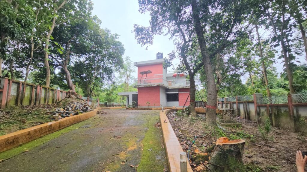 সরকারি সম্পদ রক্ষার দায়িত্ব যাদের, তাদের বিরুদ্ধেই সরকারি গাছ কাটার অভিযোগ উঠেছে। বান্দরবানে গণপূর্ত বিভাগের কার্যালয় ও নির্বাহী প্রকৌশলীর বাসভবন চত্বরের ছয়টি সরকারি গাছ ডালপালা ছাঁটাইয়ের কথা বলে গোড়া থেকে কেটে ফেলার অভিযোগ পাওয়া গেছে। কাটা গাছগুলোর মধ্যে রয়েছে মেহগনি, ঝাউ, অর্জুন, আম ও কাঁঠাল। অভিযোগ রয়েছে, গাছগুলো কাটার ক্ষেত্রে সংশ্লিষ্ট কর্তৃপক্ষের অনুমোদন কিংবা নির্ধারিত সরকারি প্রক্রিয়া অনুসরণ করা হয়নি। এমনকি গাছ কাটার অনুমোদনসংক্রান্ত কোনো নথিপত্রও সংশ্লিষ্টদের কাছে নেই বলে অভিযোগ উঠেছে। আরও অভিযোগ রয়েছে, গাছগুলো কাটার পর সেগুলোর ৭ থেকে ১০ ফুট লম্বা অংশ ট্রাকে করে বান্দরবান শহরের উজানীপাড়া এলাকার একটি করাতকলে নিয়ে যাওয়া হয়েছে। সেখানে কাটা গাছের কাঠ স্তূপ করে রাখা হয়েছে বলে স্থানীয় সূত্রে জানা গেছে। অভিযোগকারীদের ভাষ্য, গণপূর্ত বিভাগের কার্যালয় ও নির্বাহী প্রকৌশলীর বাসভবন এলাকায় থাকা কয়েকটি গাছের ডালপালা ছাঁটাই ও পরিষ্কার করার উদ্যোগ নেওয়া হয়েছিল। কিন্তু ডালপালা ছাঁটাইয়ের পরিবর্তে পর্যায়ক্রমে ছয়টি গাছই গোড়া থেকে কেটে ফেলা হয়। খোঁজ নিয়ে জানা গেছে, সোমবার থেকে বৃহস্পতিবার পর্যন্ত কয়েক ধাপে গাছগুলো কাটা হয়। এরপর কাটা গাছের বড় অংশ ট্রাকে করে উজানীপাড়ার একটি করাতকলে নিয়ে যাওয়া হয় বলে অভিযোগ রয়েছে। সরেজমিনে দেখা যায়, গণপূর্ত বিভাগের নির্বাহী প্রকৌশলীর বাসভবনের দুই পাশে ও ভবনের পাশে থাকা আম ও কাঁঠালসহ চারটি গাছ কেটে ফেলা হয়েছে। কাটা গাছের কিছু অংশ বাসভবনের প্রবেশমুখে স্তূপ করে রাখা হয়েছে। অন্যদিকে কার্যালয়ের দেয়ালঘেঁষে থাকা ঝাউ ও অর্জুন গাছ দুটিও কেটে ফেলা হয়েছে। কাটা অংশের কিছু জায়গা পাতা দিয়ে ঢেকে রাখা হয়েছে। সরকারি গাছ কাটার ক্ষেত্রে সংশ্লিষ্ট কর্তৃপক্ষের অনুমোদন এবং নির্ধারিত সরকারি প্রক্রিয়া অনুসরণের বিধান রয়েছে। সরকারি, স্বায়ত্তশাসিত ও শিক্ষা প্রতিষ্ঠানের প্রাঙ্গণসহ বিভিন্ন সরকারি জায়গায় থাকা গাছ অপসারণের ক্ষেত্রেও অনুমোদন ও নির্ধারিত প্রক্রিয়া অনুসরণের প্রয়োজন হয়। এ ছাড়া সরকারি গাছ কর্তন, অপসারণ এবং প্রয়োজনে নিলামে বিক্রির ক্ষেত্রেও নির্দিষ্ট প্রশাসনিক প্রক্রিয়া রয়েছে। কিন্তু বান্দরবান গণপূর্ত বিভাগের অধীনে থাকা ছয়টি গাছ কাটার ক্ষেত্রে এসব প্রক্রিয়া অনুসরণ করা হয়েছে কি না, সেটিই এখন বড় প্রশ্ন হয়ে দেখা দিয়েছে। কার অনুমতিতে গাছগুলো কাটা হয়েছে, গাছ কাটার অনুমোদনপত্র কোথায় এবং কাটা কাঠের কী করা হয়েছে—এসব প্রশ্নেরও স্পষ্ট কোনো উত্তর পাওয়া যায়নি। গাছ কাটার ঘটনায় গণপূর্ত বিভাগের গাড়িচালক ইকবাল এবং ভাউচারের দায়িত্বে থাকা সুমন নামের দুই ব্যক্তির বিরুদ্ধে অভিযোগ উঠেছে। অভিযোগ রয়েছে, তাদের যোগসাজশে ডালপালা ছাঁটাইয়ের নামে গাছগুলো গোড়া থেকে কেটে ফেলা হয়। পরে কাটা কাঠের একটি অংশ ট্রাকে করে উজানীপাড়ার করাতকলে নিয়ে যাওয়া হয়। তবে অভিযোগের বিষয়ে ওই দুই ব্যক্তির বক্তব্য পাওয়া যায়নি। ফলে তাদের বিরুদ্ধে ওঠা অভিযোগের সত্যতা স্বাধীনভাবে যাচাই করা সম্ভব হয়নি। নিউ গুলশান এলাকার বাসিন্দা রহমত আলী বলেন, “শুরুতে ডালপালা কাটতে দেখেছি। কিন্তু কখন যে গাছ কেটে ফেলেছে, সেটা দেখতে পাইনি। গাছের কাঠ ট্রাকে করে কখন বের করে নিয়ে গেছে, সেটিও অবাক করার মতো বিষয়। এ বিষয়ে তদন্ত হওয়া দরকার।” গণপূর্ত বিভাগের প্রবেশপথের দারোয়ান ফোরকান বলেন, গাছ কেটে ফেলার বিষয়টি তিনি দেখেননি। কাটা গাছের অংশ ট্রাকে করে নিয়ে যাওয়ার বিষয়টিও তাঁর জানা নেই বলে জানান তিনি। নাম প্রকাশে অনিচ্ছুক গণপূর্ত বিভাগের এক ব্যক্তি বলেন, সোমবার থেকে বৃহস্পতিবার পর্যন্ত পর্যায়ক্রমে গাছগুলো কাটা হয়েছে। পরে গাছগুলো করাতকলে পাঠানো হয়েছে। এ কাজে ভাউচারের দায়িত্বে থাকা সুমন ও গাড়িচালক ইকবাল জড়িত বলে তিনি দাবি করেন। অভিযোগের বিষয়ে বান্দরবান জেলা গণপূর্ত বিভাগের সহকারী প্রকৌশলী সুমিত রায় বলেন, “গাছ কাটার বিষয়ে আমি কিছুই জানি না। গাছের ডালপালা কাটতে দিয়েছিলাম। কিন্তু কে গাছগুলো কেটে ফেলেছে, তা আমি জানি না। যারা এ কাজে জড়িত, তাদের বিরুদ্ধে ব্যবস্থা নেওয়া হবে।” অন্যদিকে গণপূর্ত বিভাগের নির্বাহী প্রকৌশলী মোহাম্মদ শাহজাহান বলেন, “গাছ কাটার বিষয়ে আমি কিছুই জানি না। আপনার কাছ থেকেই প্রথম শুনলাম যে গাছগুলো কেটে নিয়ে যাওয়া হয়েছে। আমি খোঁজখবর নিয়ে আপনাকে জানাচ্ছি।” তবে তাঁর এ বক্তব্যের পর দুই সপ্তাহ পেরিয়ে গেলেও গাছ কাটার বিষয়ে তিনি আর কোনো তথ্য বা তদন্তের অগ্রগতি জানাননি বলে জানা গেছে। সরকারি সম্পদ রক্ষার দায়িত্বে থাকা একটি সরকারি বিভাগের কার্যালয় ও আবাসিক চত্বর থেকে একসঙ্গে ছয়টি গাছ কেটে ফেলার অভিযোগে স্থানীয়দের মধ্যে প্রশ্ন দেখা দিয়েছে। স্থানীয়দের দাবি, গাছগুলো কাটার অনুমোদন ছিল কি না, কে বা কারা গাছ কাটার নির্দেশ দিয়েছিল, কাটা কাঠ কোথায় নেওয়া হয়েছে এবং সরকারি সম্পদ অপসারণের ক্ষেত্রে কোনো নিয়ম ভাঙা হয়েছে কি না—এসব বিষয় তদন্ত করে দেখা প্রয়োজন। তাদের মতে, অভিযোগের সত্যতা পাওয়া গেলে জড়িতদের বিরুদ্ধে প্রশাসনিক ও আইনগত ব্যবস্থা নেওয়া উচিত। একই সঙ্গে সরকারি সম্পদ রক্ষায় দায়িত্বশীলদের জবাবদিহির আওতায় আনা এবং ভবিষ্যতে এ ধরনের ঘটনা প্রতিরোধে কার্যকর ব্যবস্থা নেওয়ারও দাবি জানিয়েছেন তারা।